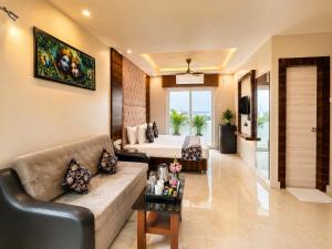 a living room with a couch and a bed at Hotel Rohit Rohini - New Aesthetic Hotel in Jagannath Puri with Restaurant, Parking, Free Wi-fi, Prime Location in Puri