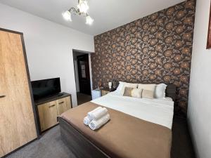 a bedroom with a large bed and a wall covered in logs at Harmonie Radauti in Rădăuţi