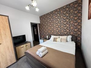 a bedroom with a large bed and a television at Harmonie Radauti in Rădăuţi