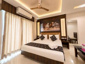 a bedroom with a bed with a painting on the wall at Hotel Rohit Rohini - New Aesthetic Hotel in Jagannath Puri with Restaurant, Parking, Free Wi-fi, Prime Location in Puri