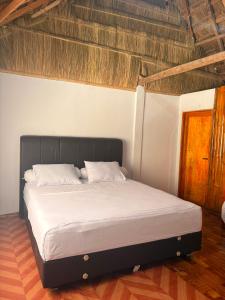 a large bed in a bedroom with a wooden floor at Queen house in Waikabubak