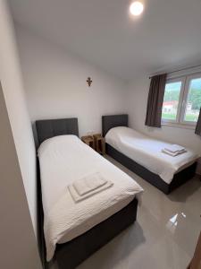 a room with two beds with white sheets at ROOMS Međugorje in Međugorje