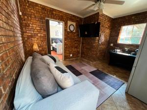 a living room with a couch and a brick wall at Kingfisher Hideaway in Nelspruit
