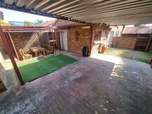 a patio with a green lawn in front of a building at Kingfisher Hideaway in Nelspruit