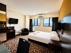 a hotel room with a bed and a television at Cozy Studio at SCSP Suites in Kota Kinabalu