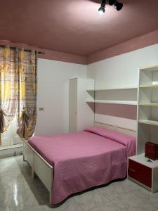 a bedroom with a bed with a pink bedspread at Residenza delle Rose in Viggianello
