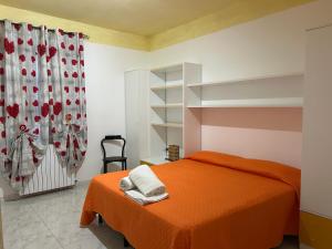 a bedroom with an orange bed and a shower at Residenza delle Rose in Viggianello