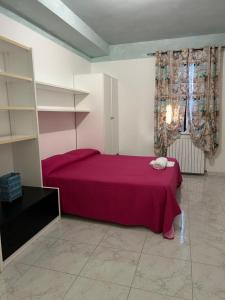a bedroom with a bed with a red bedspread at Residenza delle Rose in Viggianello