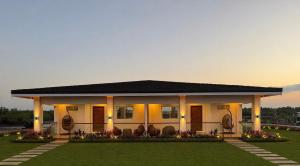 a white house with a porch and a lawn at Balai Amihan Bed & Breakfast in Talisay