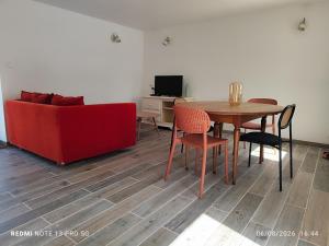 a living room with a red couch and a table at Ty eno in Plourin