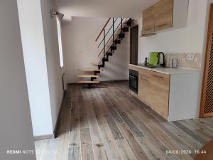 a kitchen with a wooden floor and a staircase at Ty eno in Plourin