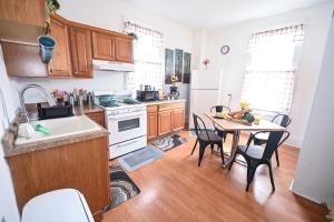 a kitchen with wooden cabinets and a table with chairs at Sunny Haven House in Jersey City +22 photos