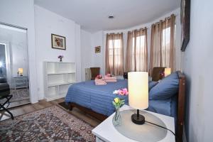 a bedroom with a blue bed and a table with a lamp at Sunny Haven House in Jersey City