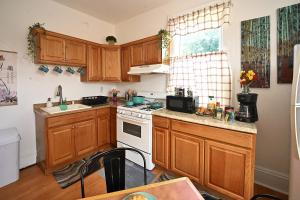 a kitchen with wooden cabinets and a white stove top oven at Sunny Haven House in Jersey City