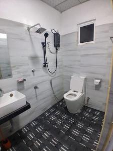 a bathroom with a toilet and a sink at Looma House Hiriketiya in Dickwella