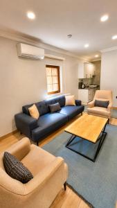 a living room with a blue couch and two chairs at Raha Villa Bungalow in Uzungöl