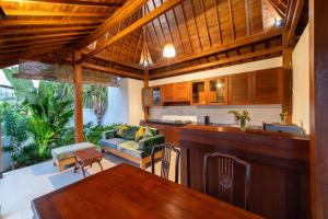 a kitchen and living room with a bar in a house at Uma Jineng Villa in Munggu