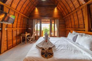 a bedroom with a bed with a dress on it at Uma Jineng Villa in Munggu
