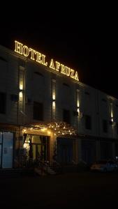 a hotel at night with a neon sign on it at Afruza Hotel in Samarkand