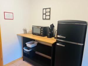 a kitchen with a black refrigerator and a microwave at Landhaus Magnus in Ramberg