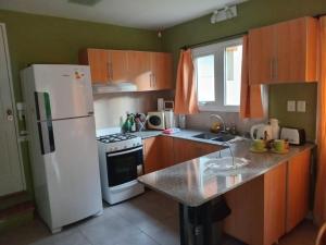 a kitchen with a white refrigerator and a counter top at Casiopea bungalo in San Carlos de Bariloche +5 photos