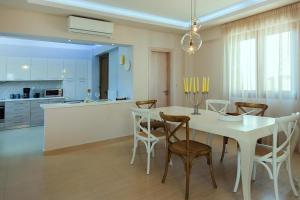 a kitchen and dining room with a white table and chairs at Cottage in Adele in Ádhele