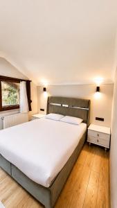 a bedroom with a large white bed and a window at Raha Villa Bungalow in Uzungöl