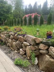 a stone retaining wall with flowers in a garden at Willa Plejady in Karpacz