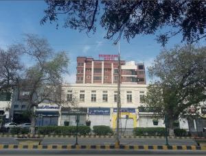 a white building with a sign on top of it at New Panoramic Hotel in Lahore