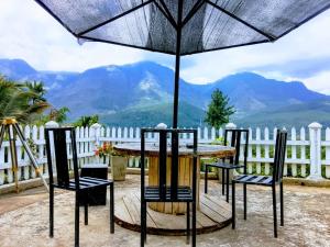 a table and chairs under an umbrella on a patio at Devil mountain villa- kalupahana in Etimole