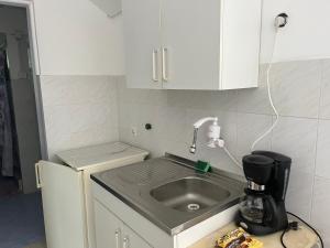 a kitchen counter with a sink and a coffee maker at Apartman Jovana in Bečej +13 photos