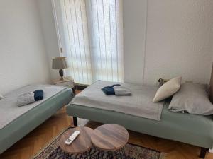 a bedroom with two twin beds and a table at Apartman Jovana in Bečej