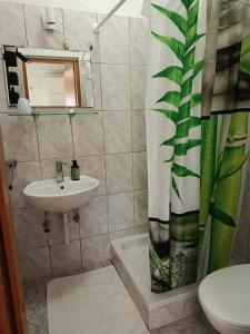 a bathroom with a sink and a shower curtain at Lovrić Studio mit Balkon in Jurandvor