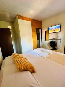 a bedroom with a bed with a blanket on it at Chalé Rosani in Pipa