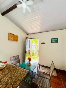 a dining room with a glass table and chairs at Chalé Rosani in Pipa
