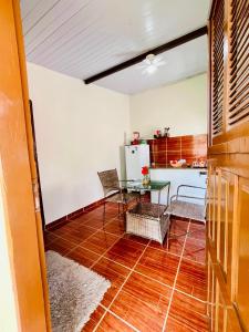 a kitchen with a table and chairs and a refrigerator at Chalé Rosani in Pipa +9 photos