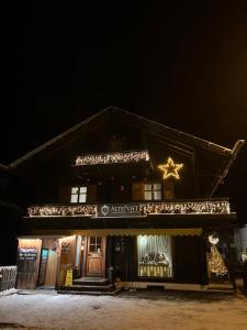 a house decorated with christmas lights at night at Appart Alte Post in Partenen