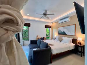 a bedroom with a bed and a couch and a chair at The Snug & The Sierra Airportel in Nai Yang Beach +128 photos