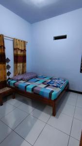 a bed in a room with a white floor at Bromo Jay House Homestay I in Sukapura