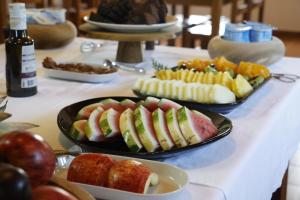 a table with two plates of sandwiches and fruit at O Monte da Estrada in Zambujeira do Mar
