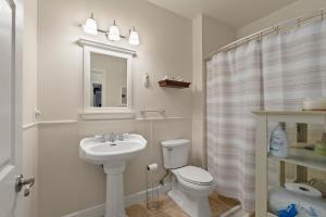 a bathroom with a sink and a toilet and a mirror at Permana Apartment in Manila