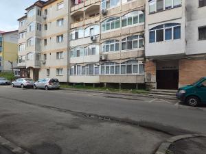an empty street with cars parked in front of a building at Verso Studio in Curtea de Argeş
