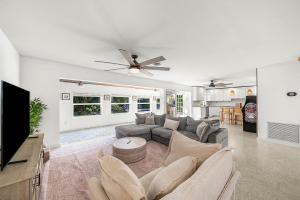 a living room with a couch and a ceiling fan at Backyard Oasis with Pool & Games in West Palm Beach