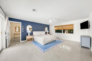 a bedroom with a bed and a blue wall at Backyard Oasis with Pool & Games in West Palm Beach +16 photos