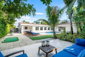a backyard with blue furniture and a pool at Backyard Oasis with Pool & Games in West Palm Beach