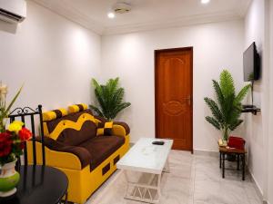 a living room with a yellow couch and a table at Ouedraogo Property Management in Ouagadougou