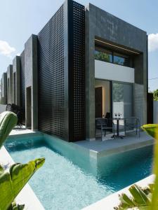 a house with a swimming pool in front of it at Three Doors Villa Complex-Faliraki in Faliraki
