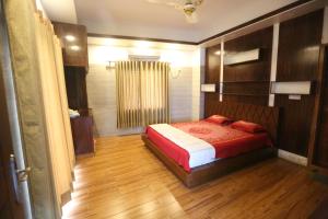 ein Schlafzimmer mit einem Bett und einem Holzboden in der Unterkunft Krishibid Resort 