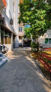 an empty street in front of a building with a tree at Nikolovi Apartment in Skopje