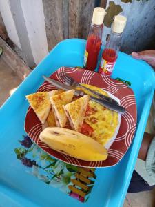 a plate of breakfast food with toast and a banana at Pin senaru accomodation in Senaru